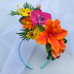 Tropical flower headband with bright orange and pink hibiscus-style flowers on a light blue band