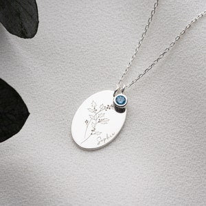 Silver birth month necklace with round engraved pendant and blue birthstone