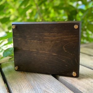 Dark wooden flower press with corner fasteners
