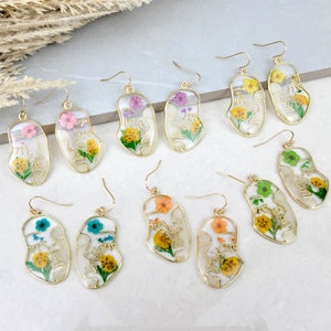 Pressed flower resin earrings, face-shaped dangle pair with gold-tone hooks in mixed colors