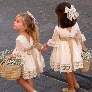 Set of 2 straw flower girl baskets with handles, held by two girls in lace dresses