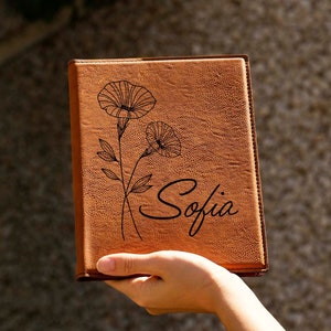 Personalized leather padfolio with embossed birth flower and script name on tan cover