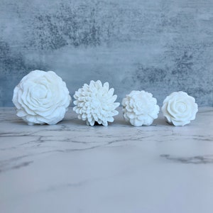 Set of four white flower-shaped soaps