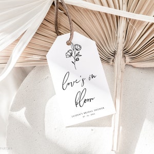 White minimalist floral tag with line art and "Love is in Bloom" text