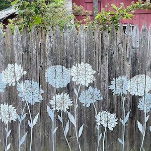 Large flower stencils painted in white on a wooden fence