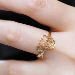 Rose gold flower ring with a rose and small leaf accents on a band