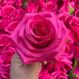 Hot pink faux silk rose head, 9cm artificial flower bloom, close-up with hand