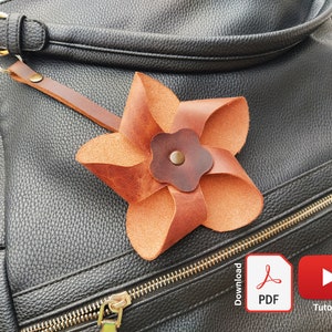 Leather flower bag ornament, tan layered petals with round center cutout.