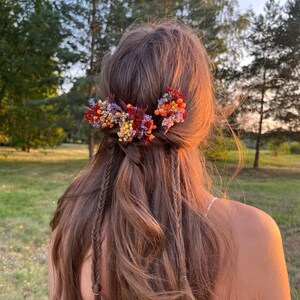 Bridal flower hair pins with terracotta and purple clusters, secured on long hair