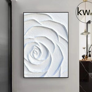 Large white 3D textured rose painting in a black-framed wall art