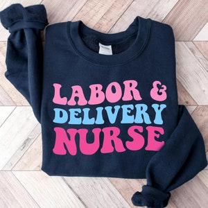 Dark navy crewneck sweatshirt with pink "LABOR & DELIVERY NURSE" text