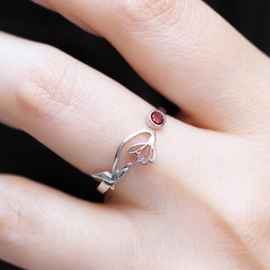Dainty sterling silver birth flower ring with small dark red gemstone on top