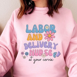 Pink labor and delivery nurse sweatshirt with colorful 'Labor and Delivery Nurse' graphic
