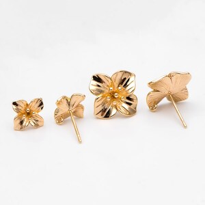 Gold-tone floral stud earrings set with earring posts and loop-back, five-petal flower design