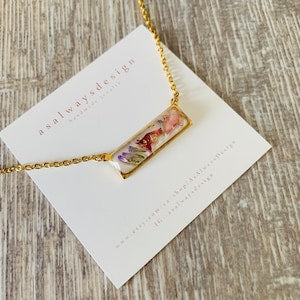 Floral resin necklace with gold-tone chain and rectangular pendant