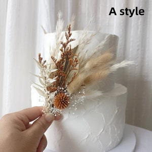 Dried flower cake topper with tan and brown pampas grass and small dried blooms