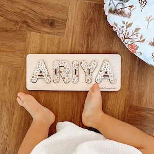 White baby name puzzle sign with peg letters spelling ARTIA