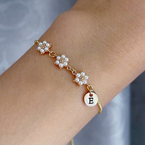 Gold-tone pearl flower bracelet with heart E charm