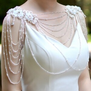 White bridal cape topper with faux pearl tassels and small floral appliques on shoulder