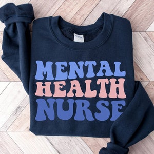 Navy sweatshirt with “MENTAL HEALTH NURSE” graphic on the front