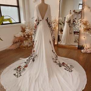 Boho wedding dress with deep V-back and botanical floral embroidery, flowing train