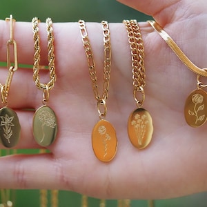 Gold tone birth-flower pendant necklace with oval engraved charms on chain