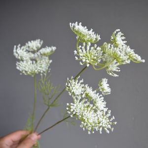 White artificial filler flowers with green stems, small bunch of faux blooms
