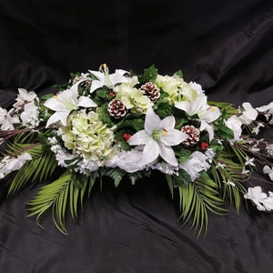 White floral cemetery saddle with mixed greenery and red accents