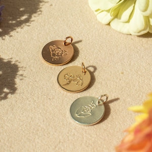 Round birth-flower pendant charms with engraved floral design, assorted finishes