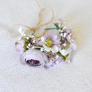 Small wrist corsage bracelet with pink and lavender flowers, greenery, and bead accents