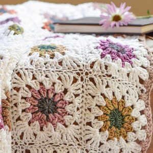 Crochet flower granny square blanket with cream base and multicolor floral motifs