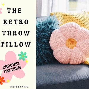 Crochet flower throw pillow pattern with large pink blossom on a plush pillow