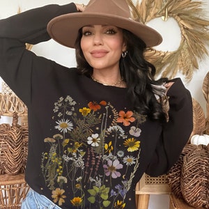 Black crewneck sweatshirt with botanical pressed flowers and wildflowers graphic