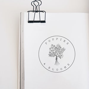 Circular floral bouquet stamp with hand-drawn flowers and leaves, floral wreath label