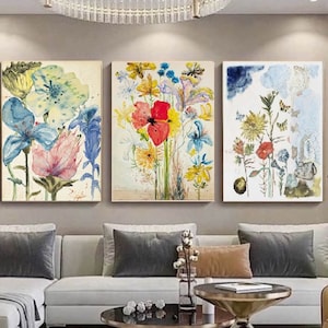 Set of 3 botanical canvas wall art prints with blue, yellow, and red flowers, framed