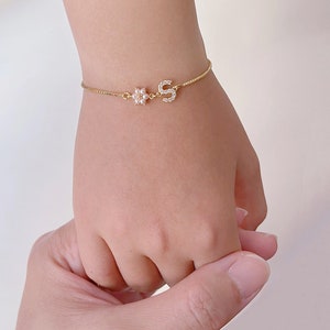Gold-tone chain bracelet with small heart charm on a child’s wrist