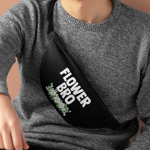 Black fanny pack with FLOWER text and floral graphic, worn crossbody