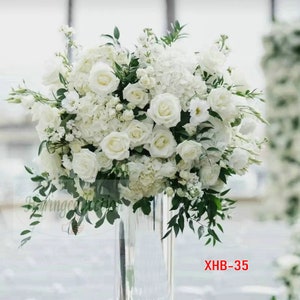 Artificial flower ball centerpiece with white roses and green leaves in vase