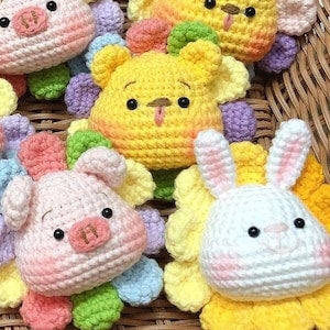 Crochet amigurumi animal plushes: yellow chick, pink pig and white bunny in a basket