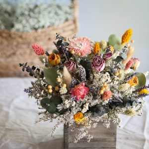 Boho dried flower centerpiece with pink roses and eucalyptus in a wooden planter