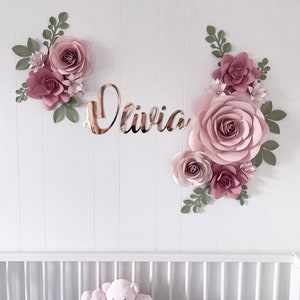 Pink paper flower wall decor with green leaves and rose bloom cluster, 'Olivia' sign