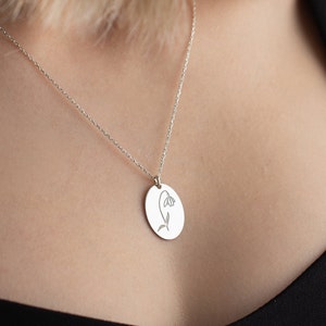 Silver oval pendant necklace with small flower engraving on fine chain