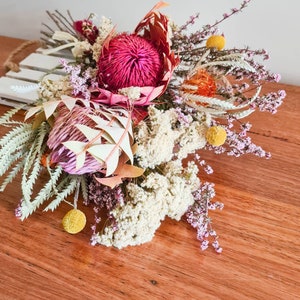 Dried native flower bouquet with red protea, purple blooms, yellow buds, and pale foliage