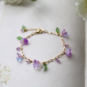 Gold-tone bracelet with purple bell-flower charms and crystal accents