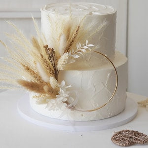 Boho dried flower wreath cake topper on white frosted cake