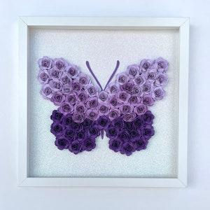 Butterfly shaped flower box with purple paper-flower butterfly in a white frame