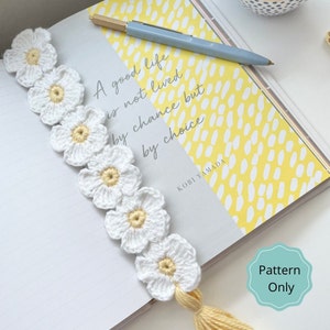 Crochet flower chain bookmark with white blossoms and a small gold tassel