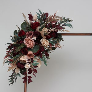 Burgundy and dusty rose faux flower arch arrangement with greenery on wooden frame