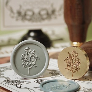Wax seal stamp kit with leaf emblem stamp heads in gray and bronze colors
