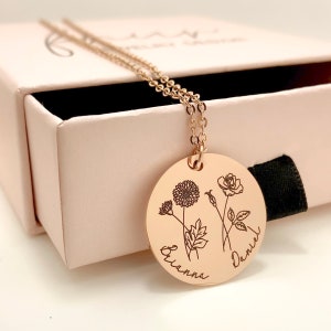 Gold-tone necklace with round pendant engraved with birth flowers and names